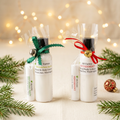 Christmas lotion and lip balm sets with festive greenery and warm holiday lights